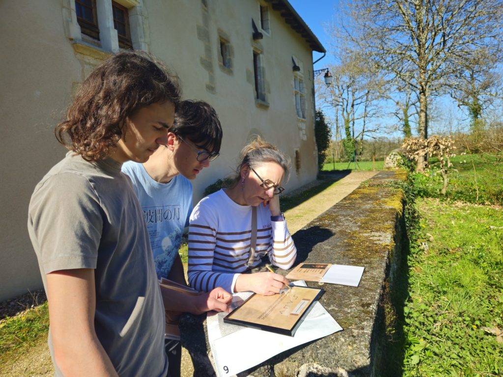 Trois personnes résolvant une énigme de la Murder Party de Saint Jean de Côle.