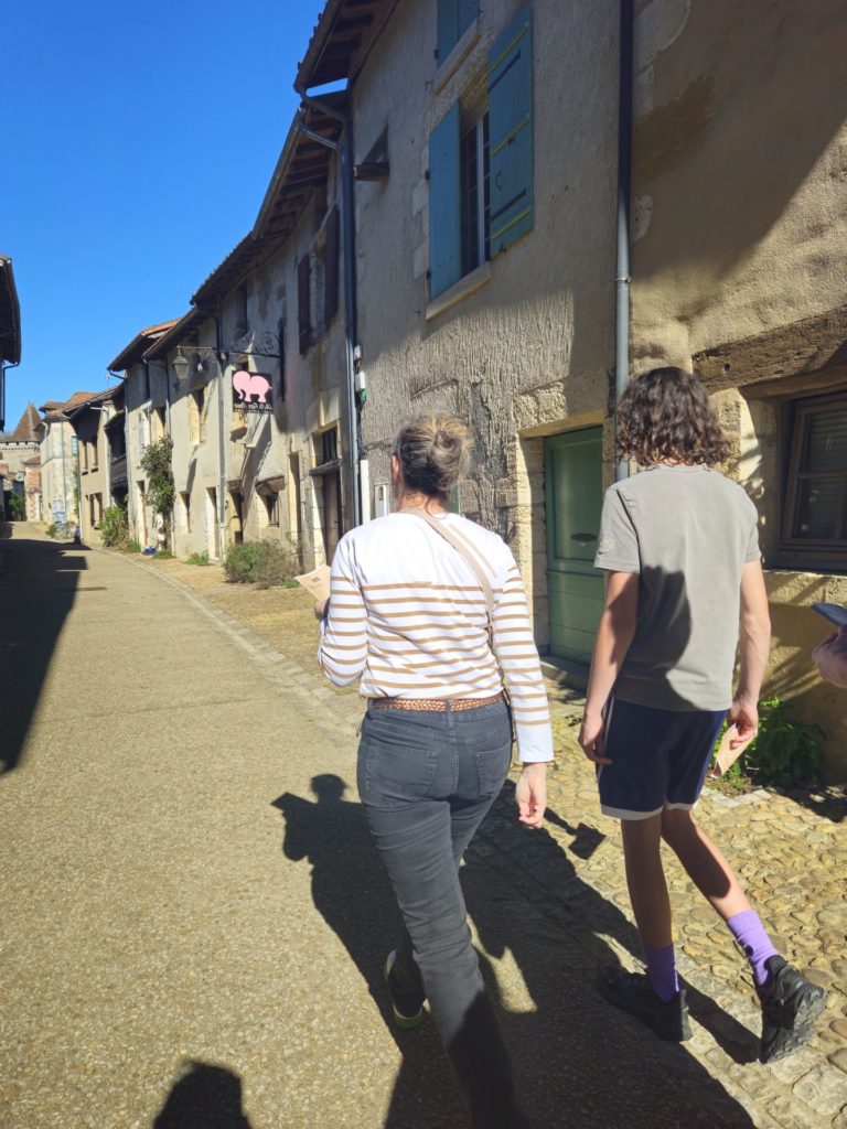 Deux participants de la Murder Party de Saint Jean de Côle marchant dans la plus vieille rue du village.
